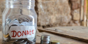 Give-donate-,money-jar-with-a-label-with-the-word-donations-on-it