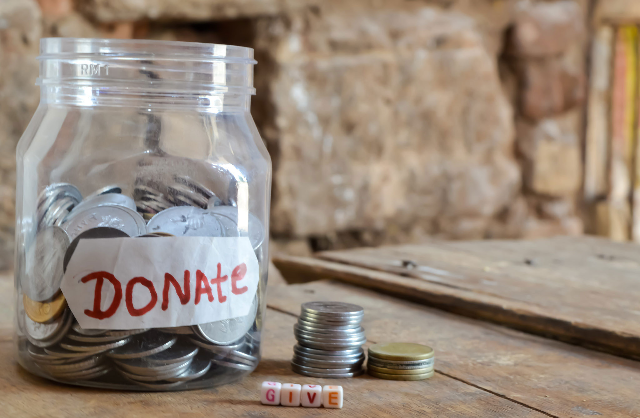 Give-donate-,money-jar-with-a-label-with-the-word-donations-on-it