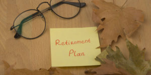Eye Glass over a sticky note with a Retirement Plan Text on it